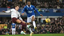 Pemain Manchester City, John Stones (kiri) berebut bola dengan pemain Everton, Beto pada laga lanjutan Liga Inggris 2023/2024 di Goodison Park, Liverpool, Inggris, Kamis (28/12/2023) dini hari WIB. (AFP/Paul Ellis)