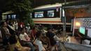 Sejumlah warga menggelar nobar pertandingan Timnas Indonesia melawan Bahrain dalam pertandingan Grup C putaran ketiga Kualifikasi Piala Dunia 2026 zona Asia di kawasan Menteng Jaya, Jakarta, Selasa (25/5/2025). (Bola.com/M Iqbal Ichsan)