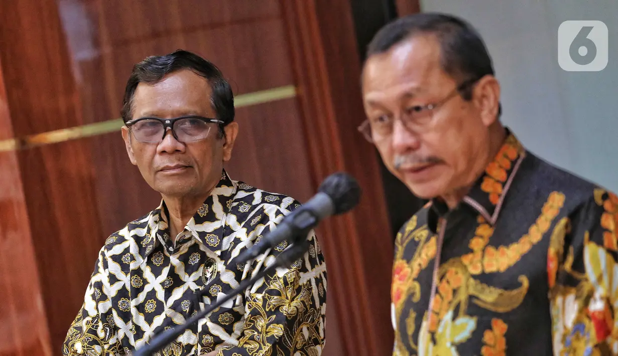 Menteri Koordinator Bidang Politik, Hukum, dan Keamanan (Menko Polhukam) Mahfud MD (kiri) mendampingi Ketua Komnas HAM Ahmad Taufan Damanik (kanan) menyampaikan keterangan di sela penyerahan berkas laporan terkait investigasi tragedi Kanjuruhan di Kantor Menko Polhukam, Jakarta, Kamis (3/11/2022). Menko Polhukam mewakili Presiden Joko Widodo atau Jokowi menerima laporan terkait investigasi tragedi Kanjuruhan yang berisi rekomendasi untuk membekukan seluruh kegiatan PSSI. (Liputan6.com/Angga Yuniar)