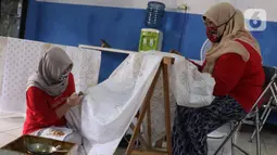 Perajin batik sedang menyelesaikan proses pembuatan batik tulis di Sanggar Batik Kembang Mayang, Larangan, Tangerang, Banten, Minggu (19/7/2020). Kain batik tulis dengan motif khas Tangerang ini dijual mulai dari Rp 450.000. (Liputan6.com/Angga Yuniar)