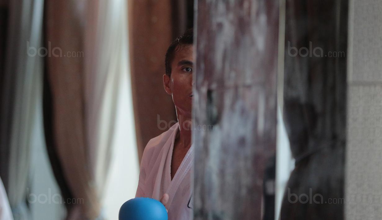 Jintar Simanjuntak memanfaatkan waktu istirahat dengan berlatih di depan cermin di The Belezza, Permata Hijau, Jakarta, Senin (07/8/2017). Jintar akan turun pada kelas 67 kg kategori komite pada ajang SEA Games 2017. (Bola.com/Nicklas Hanoatubun)