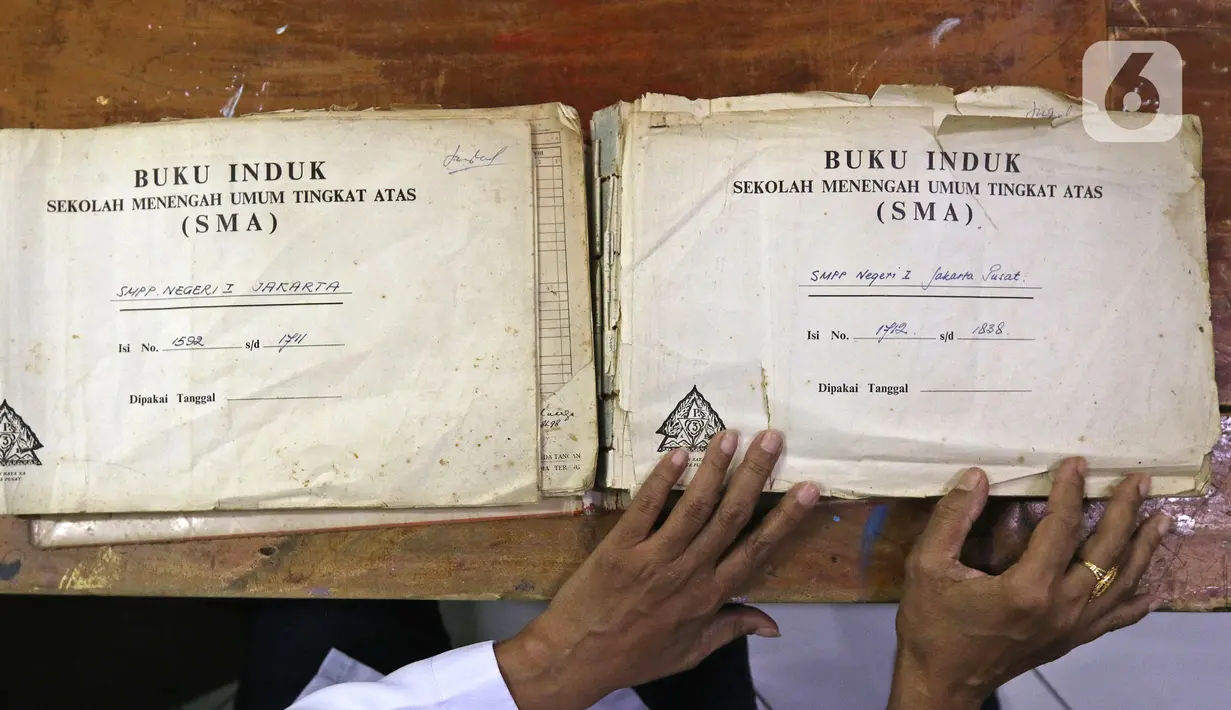 Petugas Dinas Perpustakaan dan Kearsipan (Dispusip) Provinsi DKI Jakarta memeriksa arsip sekolah di SMAN 77, Cempaka Putih, Jakarta Pusat, Rabu (24/11/2021). Digitalisasi arsip untuk meningkatkan kesadaran pentingnya menata dan menyelamatkan arsip penting. (Liputan6.com/Herman Zakharia)