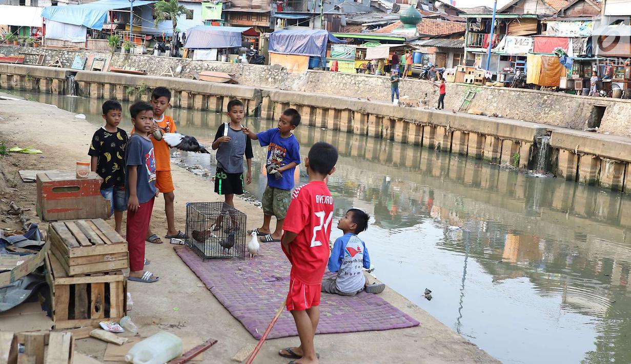 Anak-anak bermain di bantaran anak Sungai Ciliwung, Jakarta, Rabu (6/6). Meskipun tidak layak sebagai tempat bermain, namun lokasi itu menjadi tempat bagi anak-anak di kawasan tersebut untuk menunggu waktu berbuka. (Liputan6.com/Immanuel Antonius)