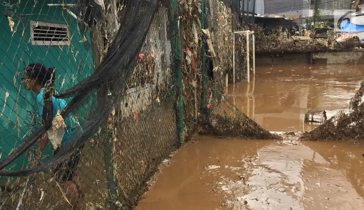 Aktivitas warga di lapangan futsal di kawasan Rawajati, Jakarta, Selasa (6/2). Banjir yang merendam kawasan tersebut menyebabkan lumpur dan sampah mengendap di setiap sudut sehingga mengganggu aktivitas warga. (Liputan6.com/Immanuel Antonius)
