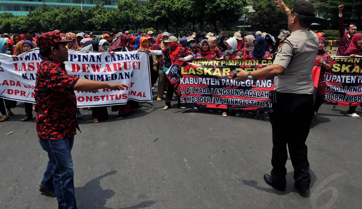 Seorang petugas tampak mengawal aksi long march ratusan massa Laskar Dewaruci menuju MK, Jakarta, (8/10/14). (Liputan6.com/Johan Tallo) 