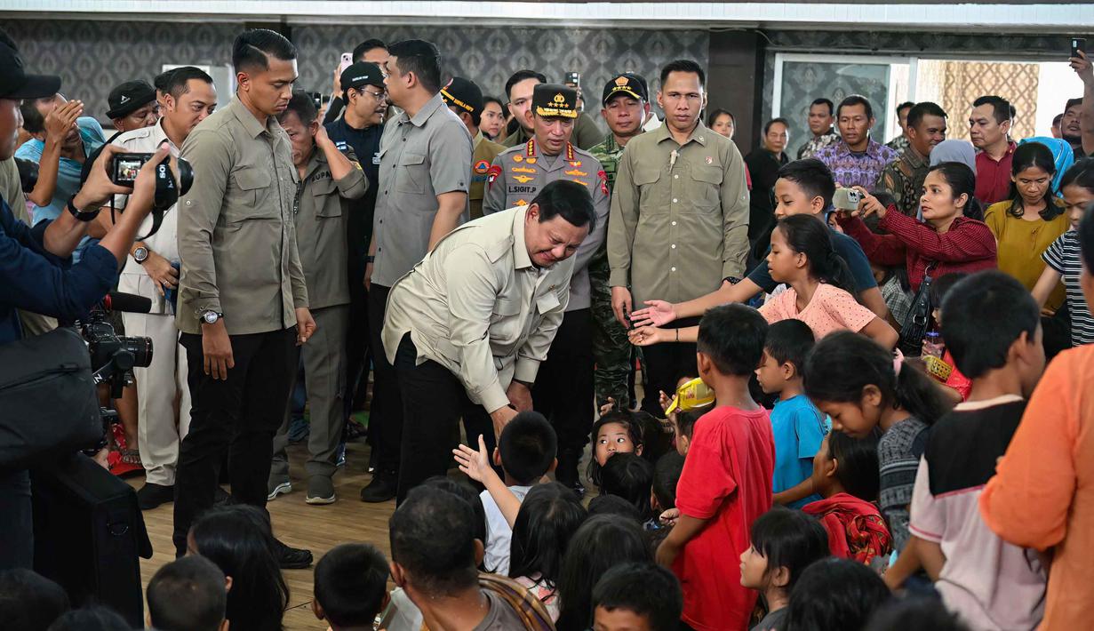 Presiden Republik Indonesia, Prabowo Subianto (tengah), bertemu dengan anak-anak korban banjir bandang di posko pengungsian Pandan, Tapanuli Tengah, Provinsi Sumatera Utara, pada 1 Desember 2025. Presiden Republik Indonesia, Prabowo Subianto mengunjungi meninjau langsung penanganan dampak banjir yang melanda Tapanuli Tengah, Provinsi Sumatera Utara, pada Senin 1 Desember 2025. (YT Hariono/AFP)