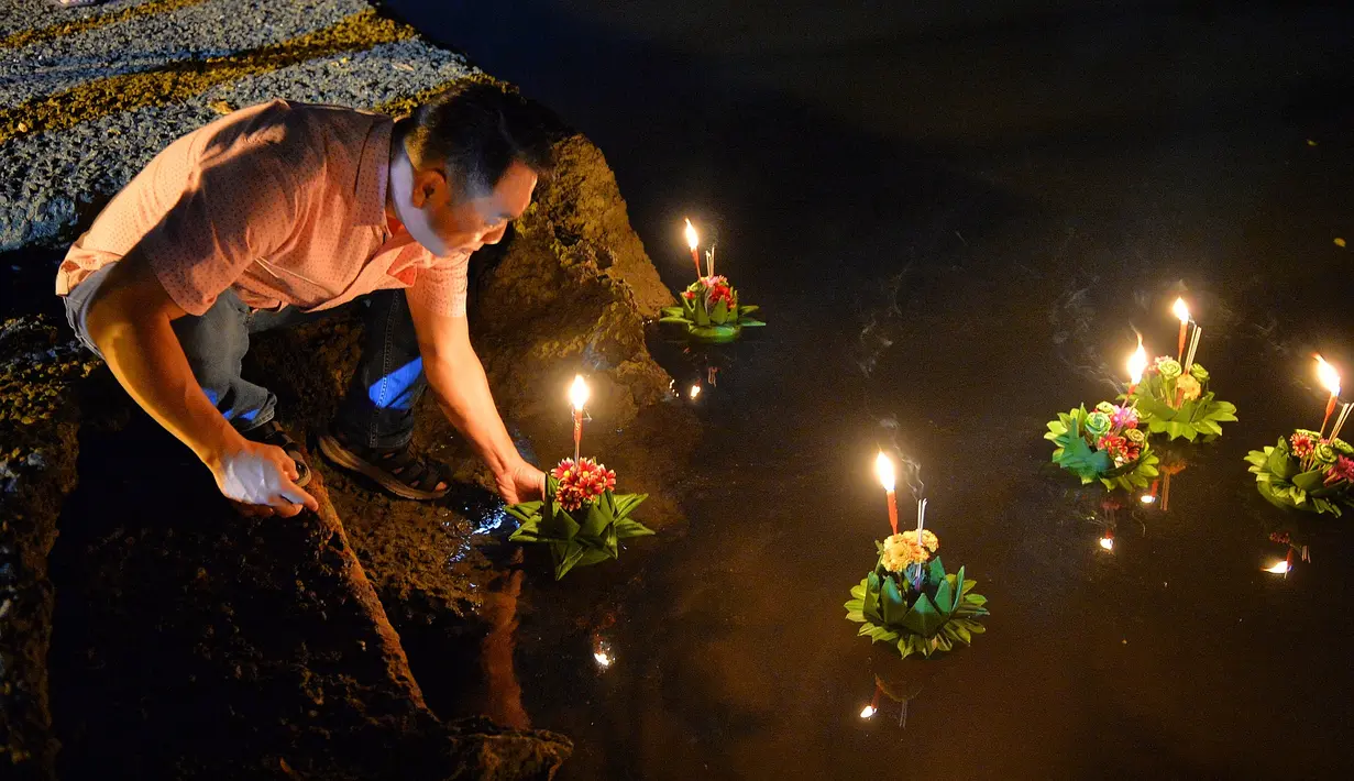 Seorang pria bersiap menghanyutkan lentera air dalam Festival Loy Krathong di Bandar Seri Begawan, Brunei (31/10/2020).  Sekitar 250 orang termasuk sejumlah warga Thailand yang tinggal di Brunei menghanyutkan lentera air untuk perdamaian dan keberuntungan. (Xinhua/Jeffrey Wong)