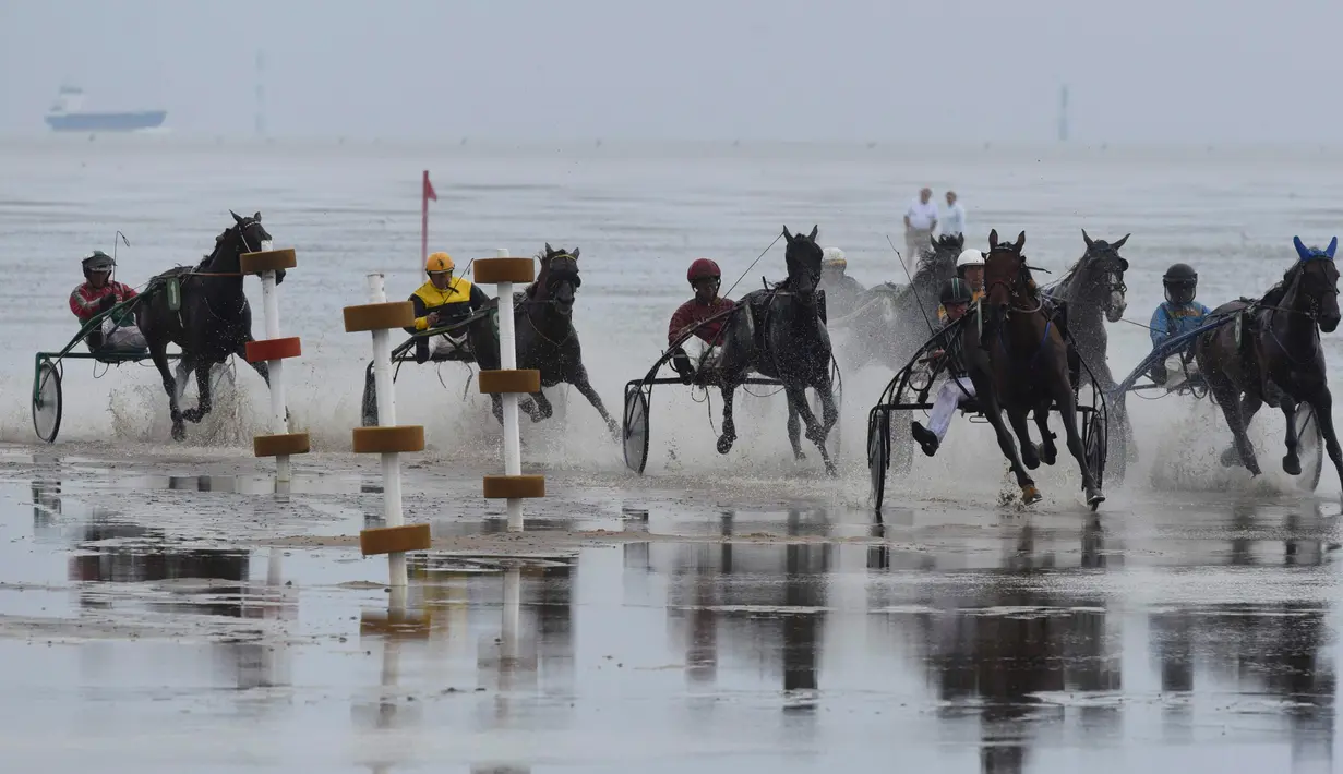 Sejumlah peserta memacu kudanya di atas lumpur saat berkompetisi di Wadden Race, Lower Saxony, Jerman, Minggu (12/7/2015).Pacuan kuda ini merupakan salah satu olaraga kuda yang unik karena dilakuakan di tepi laut. (REUTERS/Fabian Bimmer)