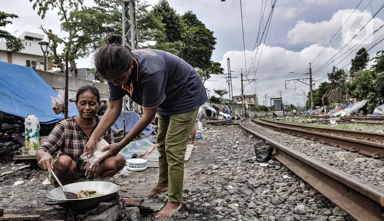 Tunawisma beraktivitas di dekat gubuknya yang berada di bantaran rel kereta api kawasan Senen, Jakarta, Minggu (14/2/2021). Mayoritas penghuni bantaran rel di kawasan ini adalah pemulung dengan rata-rata berpenghasilan Rp30ribu per hari. (merdeka.com/Iqbal S. Nugroho)