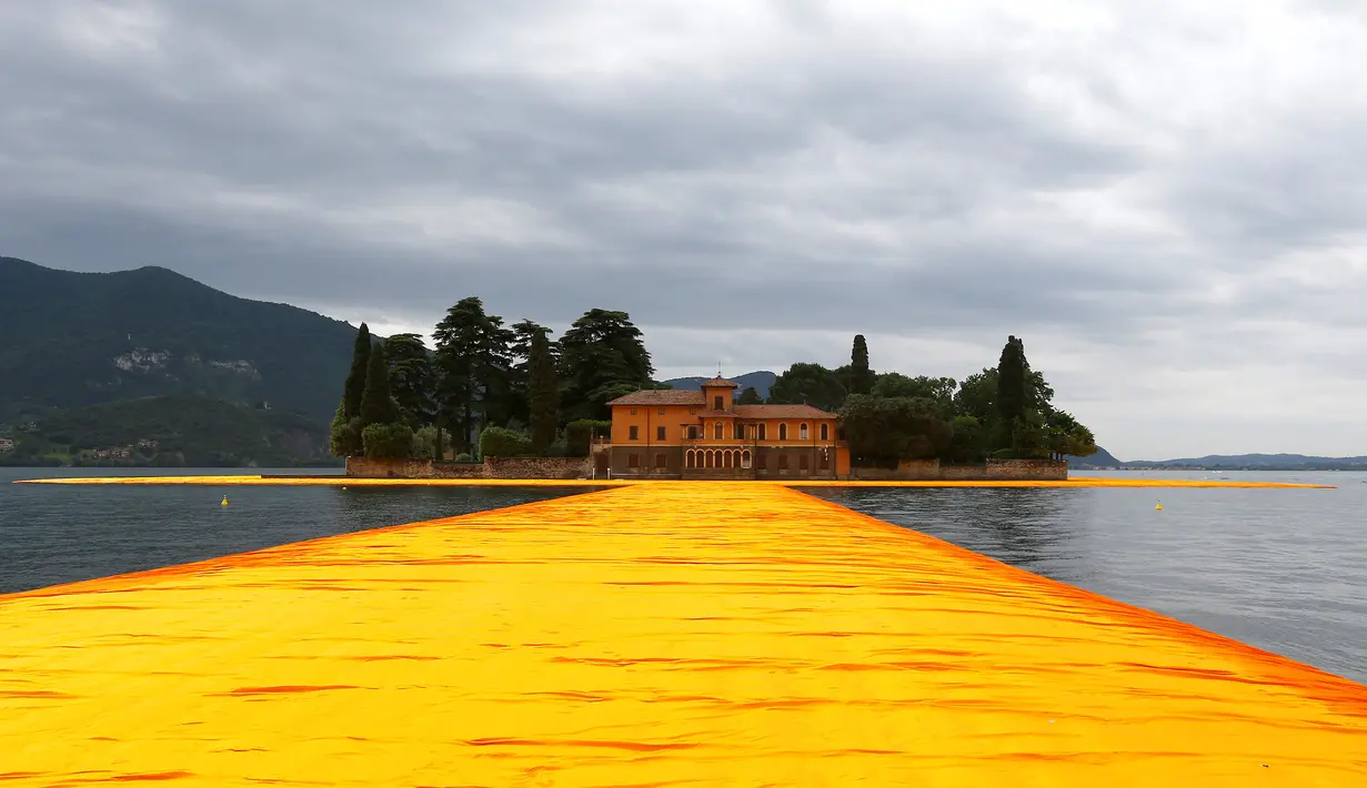 Instalasi seni 'The Floating Piers' buatan seniman  Christo Vladimirov Yavachev atau dikenal sebagai Christo , di Danau Iseo , Italia utara , (16/6).Pria 80 tahun ini  merancang karya seni besarnya untuk menarik wisatawan.  (REUTERS / Stefano Rellandini)