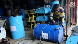 Pekerja sedang mengelas drum bekas untuk bahan membuat kursi di industri kecil Ali Kreatif, Parung Bogor, Selasa (30/1). Industri yang beromset 20 juta rupiah setiap minggunya juga memproduksi tempat sampah, lemari hingga meja. (Liputan6.com/Fery Pradolo)