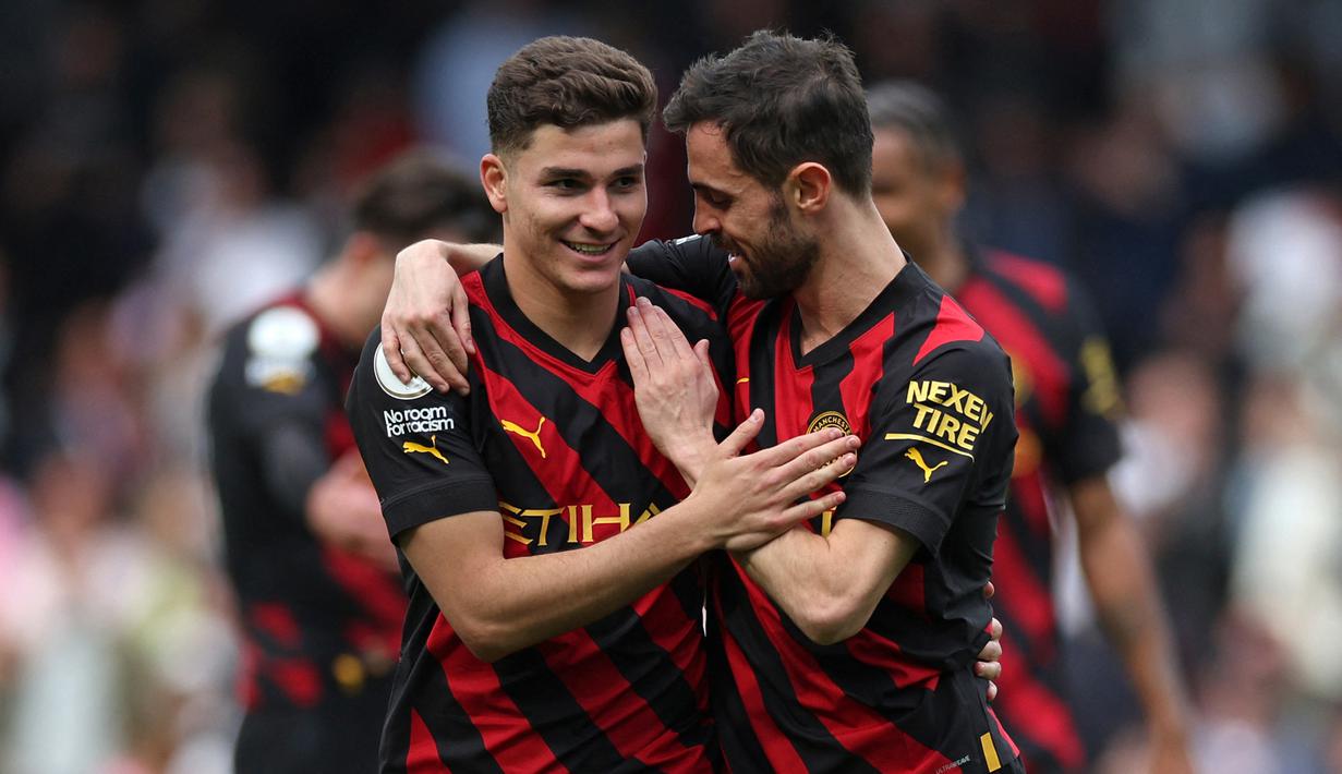 Pemain Manchester City, Julian Alvarez (kiri), mendapatkan selamat dari Bernando Silva setelah mencetak gol ke gawang Fulham dalam pertandingan pekan ke-34 Premier League 2022/2023 yang berlangsung di Craven Cottage, Minggu (30/4/2023). (AFP/Adrian Dennis)