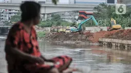 Warga saat melihat aktivitas pekerja menyelesaikan proyek Normalisasi Sungai Ciliwung di kawasan Cawang, Kramat Jati, Jakarta Timur, Rabu (7/12/2022). Kepala Dinas SDA Yusmada Faizal mengatakan anggaran itu akan digunakan untuk pembebasan lahan di empat kelurahan prioritas dalam program normalisasi Sungai Ciliwung. (merdeka.com/Iqbal S. Nugroho)