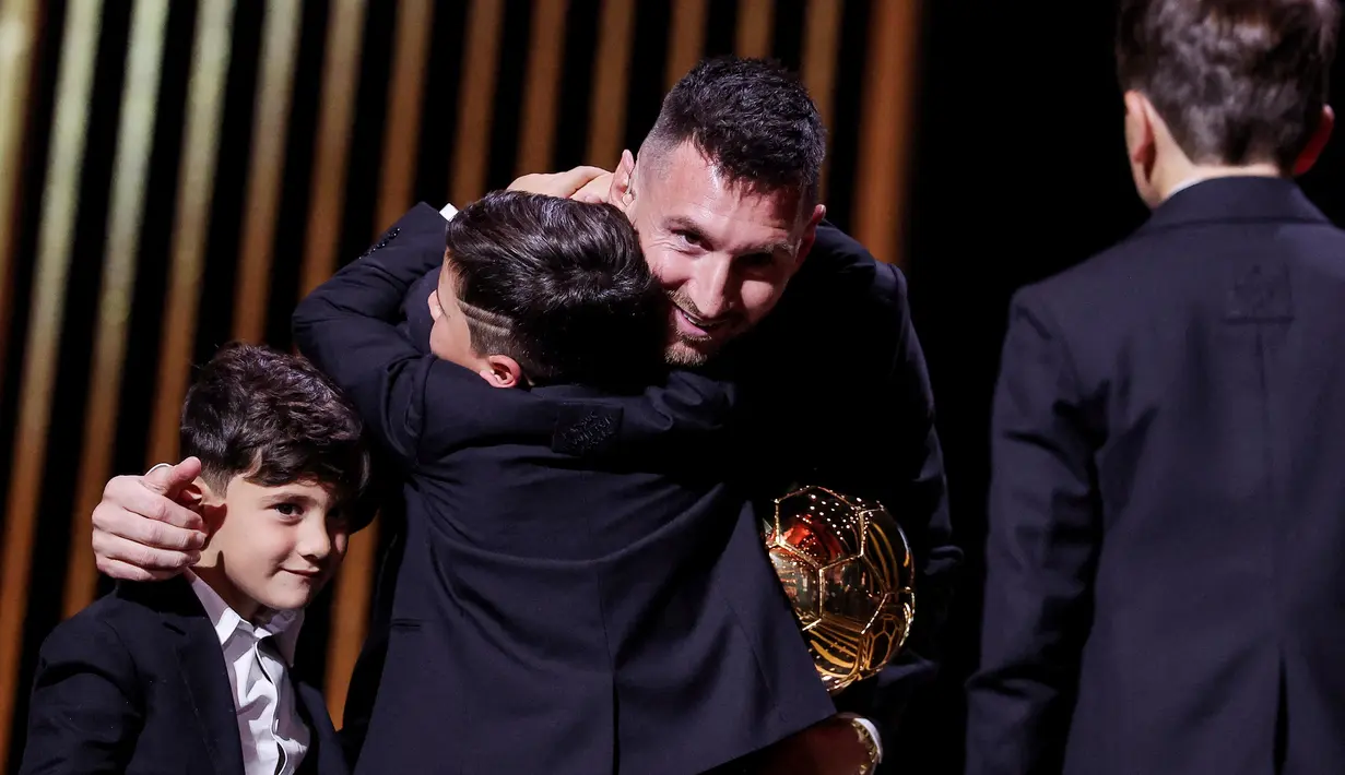 Pemain Inter Miami, Lionel Messi, dipeluk anaknya saat menerima penghargaan Ballon d'Or di Theatre du Chatelet, Paris, Selasa (31/10/2023). La Pulga berhasil menyabet penghargaan Ballon d'Or 2023 atau yang kedelapan sepanjang kariernya. (AFP/Franck Fife)