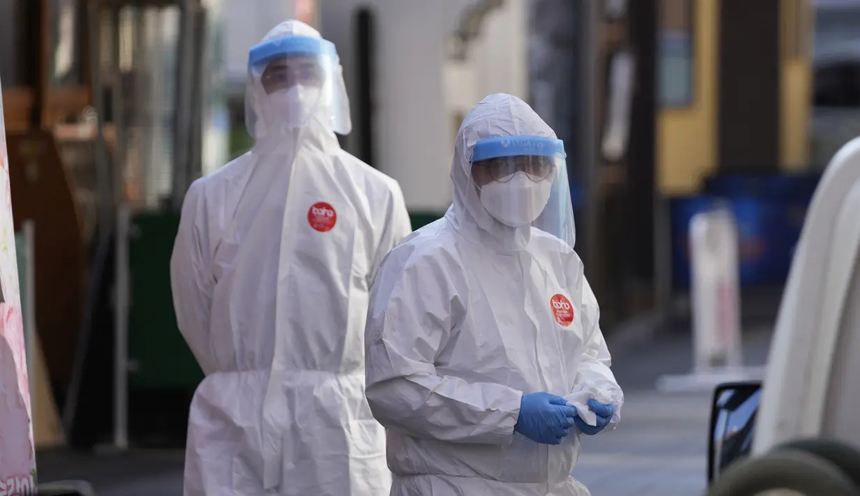 Petugas kesehatan setempat mengenakan alat pelindung diri saat bersiap untuk mendisinfeksi bagian depan toko sebagai tindakan pencegahan terhadap virus corona COVID-19 di Seoul, Korea Selatan, 29 Oktober 2021. (AP Photo/Lee Jin-man)
