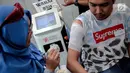 Petugas Komunitas Gerak Bareng menghapus tato dalam Hijrah Fest 2018 di Jakarta, Sabtu (10/11). Selain menyetor hapalan surat Alquran, peserta juga diharuskan menyertakan surat medical check up HIV, diabetes dan hepatitis. (Liputan6.com/Faizal Fanani)