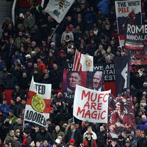 Tanpa kawalan sejumlah pemain inti, Setan Merah berhasil meredam tekanan Newcastle United. Tampak dalam foto, para penggemar United mengibarkan bendera menjelang dimulainya pertandingan sepak bola Liga Premier Inggris antara Manchester United dan Newcastle United di di Stadion Old Trafford, pada 26 Desember 2025 waktu setempat atau Sabtu (27/12/2025) dini hari WIB. (Darren Staples/AFP)