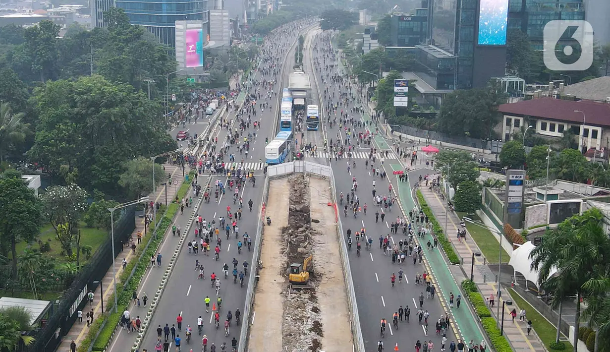 Foto udara aktivitas warga di kawasan Bundaran HI, Menteng, Jakarta Pusat, Minggu (22/5/2022). Pemprov DKI Jakarta kembali menggelar Hari Bebas Kendaraan Bermotor (HBKB) di sejumlah ruas jalan Ibu Kota. HBKB yang digelar pukul 06.00 – 10.00 tersebut dalam rangka meningkatkan kualitas udara di Jakarta. (Liputan6.com/Herman Zakharia)