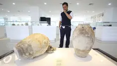 Pengunjung melihat koleksi Galeri Barang Muatan Kapal Tenggelam (BMKT) di Gedung Mina Bahari IV, Kementerian Kelautan dan Perikanan (KKP), Jakarta, Selasa (14/3). Sekitar 1.500 artefak itu dari muatan kapal yang tenggelam. (Liputan6.com/Immanuel Antonius)