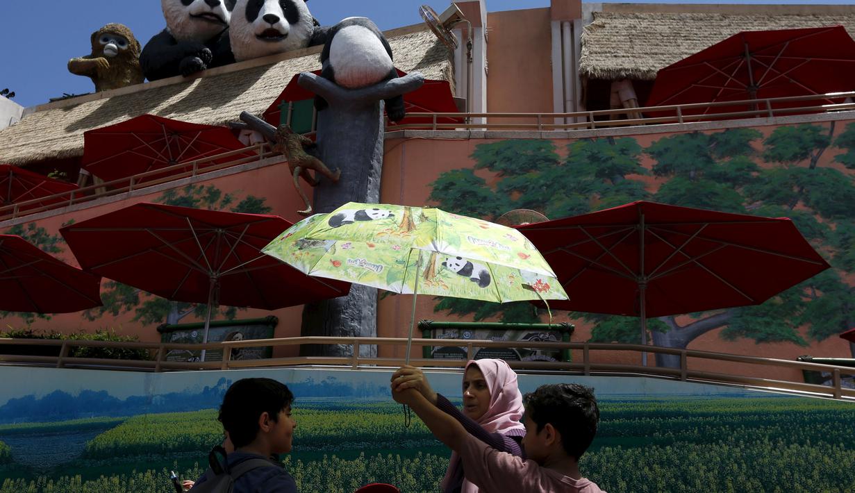 Tampak sebuah keluarga sedang berada diluar tempat penangkaran Panda raksasa Jia Jiadi Hong Kong Ocean Park, China, Selasa, (28/7/2015). Para pengunjung menyambut meriah ulang tahun Panda yang ke-37 ini. . (REUTERS/Bobby Yip)
