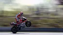 Gaya pebalap Ducati Team, Andrea Dovizioso dengan mengangkat ban pada kualifikasi MotoGp di Sirkuit Brno, (5/8/2017). Marc Marquez menjadi juara pada balapan tersebut. (AFP/Michal Cizek) 
