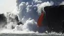 Aliran lava memancar deras dari gunung berapi Kilauea di Hawaii ke Samudra Pasifik, Rabu (1/2). Pertunjukkan alam tersebut menciptakan air terjun lava. (Shane Turpin / Lava Ocean Tours via AP)