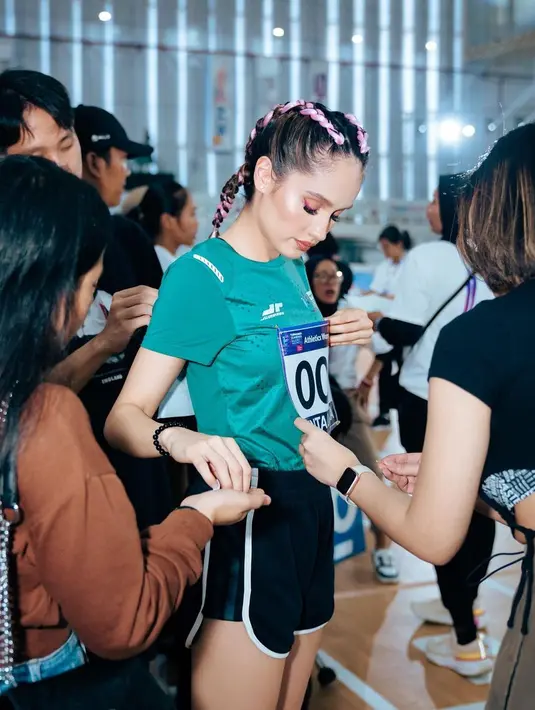 Penyanyi dan pemeran itu sedang bersiap-siap dan dipasangkan nomor di kostum yang dikenakan sebelum lari. [Instagram/claurakiehl]