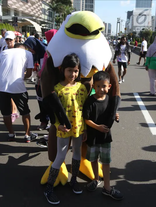 Badut karakter burung berfoto bersama anak-anak di kawasan Bundaran HI, Jakarta, Minggu (1/4). Maskot dan badut lainnya menyapa masyarakat dalam rangka sosialisasi Asian Games 2018 yang akan digelar pada 18 Agustus 2018. (Liputan6.com/Arya Manggala)