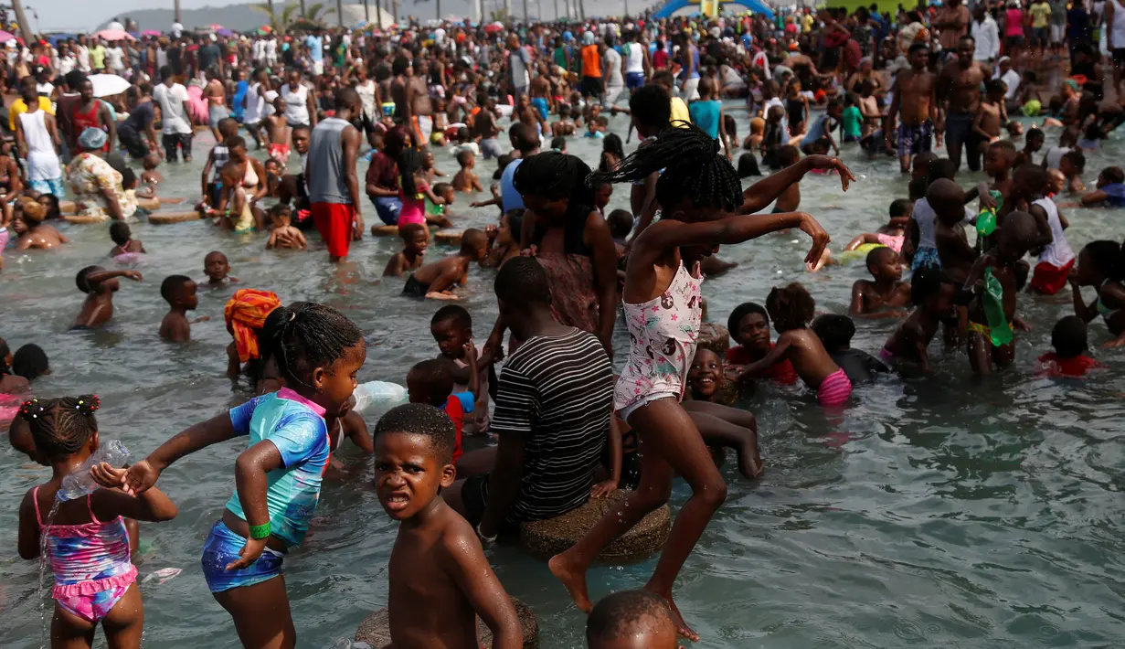 Sejumlah bocah asyik bermain di pantai saat liburan awal Tahun Baru 2017 di sebuah pantai di Durban, Afrika Selatan (1/1). (REUTERS/Rogan Ward)