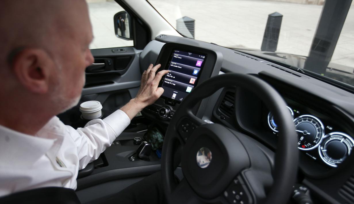 Peter Powell, sopir taksi London, menggunakan layar digital saat mengendarai taksi listrik TX eCity di jalanan London Inggris, Selasa (5/12). Taksi unik warna hitam ini telah berganti mesin elektrik untuk era modern. (AFP PHOTO / Daniel LEAL-OLIVAS)