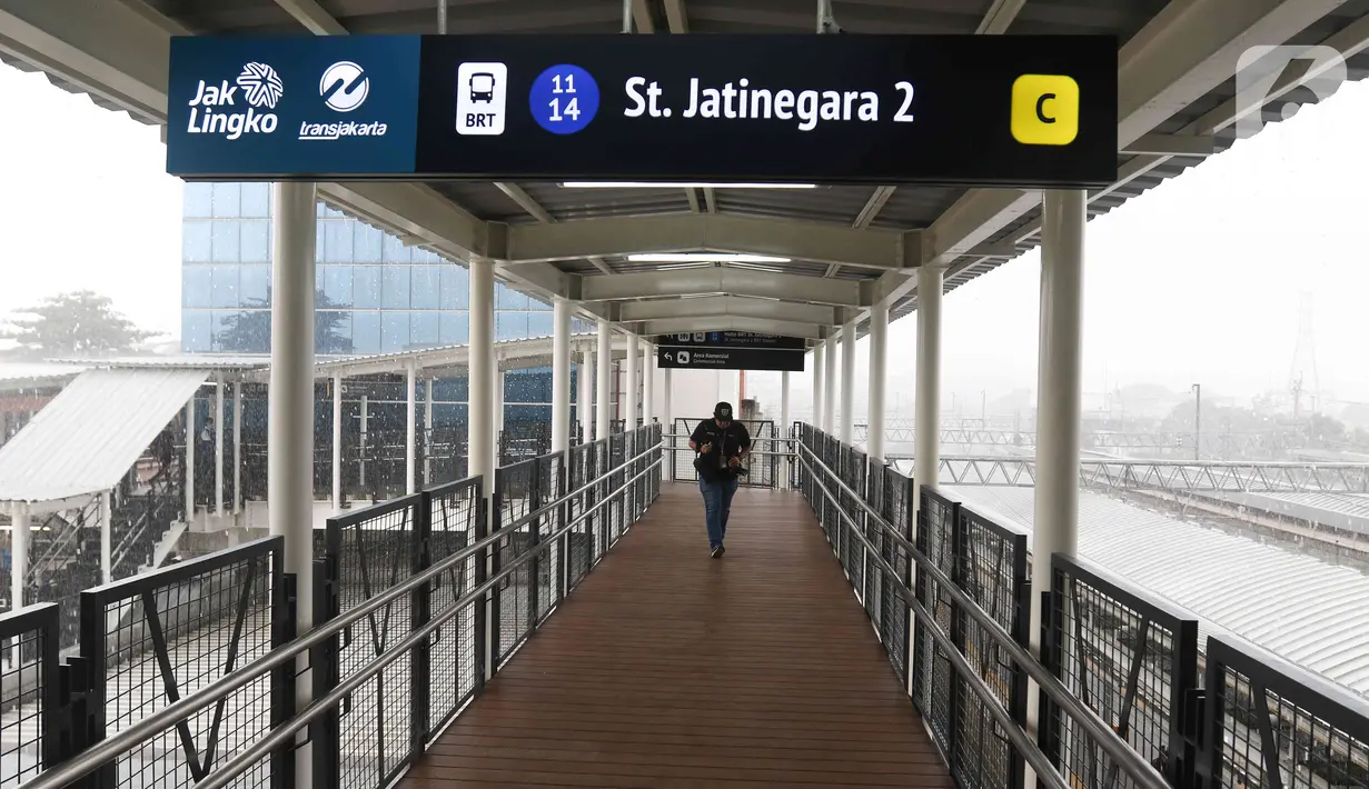 Warga melintasi jembatan penghubung Halte TransJakarta dengan  Stasiun Jatinegara di Jakarta Timur, Rabu (4/1/2023). PT Transportasi Jakarta (Transjakarta) merampungkan pengerjaan Halte Stasiun Jatinegara 2 yang terintegrasi langsung dengan Stasiun Kereta Api Jatinegara. (Liputan6.com/Herman Zakharia)