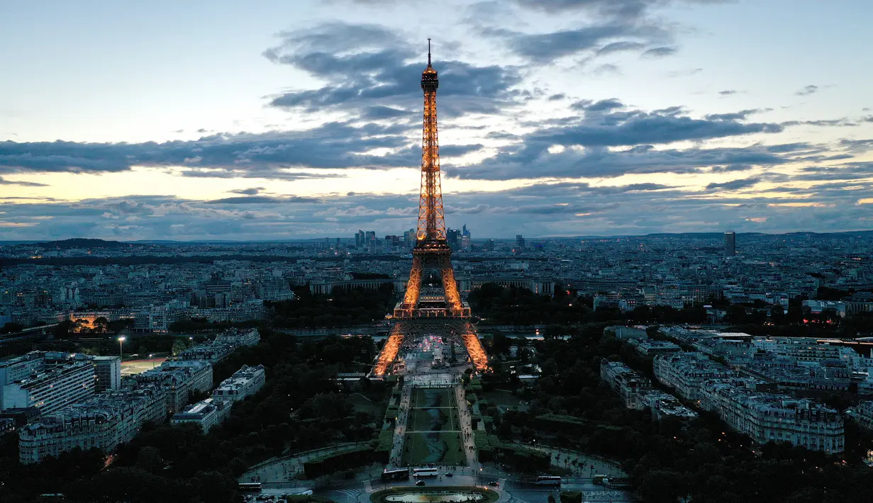 Foto udara dari lukisan raksasa "Beyond Walls" karya seniman jalanan Prancis, Saype, yang terbentang di halaman Champs de Mars, depan Menara Eiffel di Paris, 13 Juni 2019. Karya berukuran 600 meter itu bentuk dukungan kepada organisasi amal penyelamat migran, SOS Mediterranee. (Eric FEFERBERG/AFP)