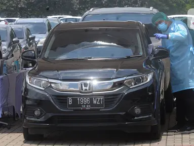 Paramedis mengarahkan pengendara mobil saat vaksinasi COVID-19 secara drive-thru di ICE BSD, Tangerang, Banten, Sabtu (13/3/2021). Sebanyak 5.000 masyarakat umum, lanjut usia (lansia), dan pengemudi ojek online (ojol) divaksin COVID-19 pada hari ini dan besok. (merdeka.com/Arie Basuki)