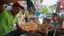 Pedagang membuat kue saat berjualan di sebuah pasar di Ibu Kota Damaskus, Suriah, Minggu (19/5/2019). Warga Suriah harus harus berhemat selama Ramadan lantaran taraf kehidupan mereka yang menyusut jauh. (Louai Beshara/AFP)