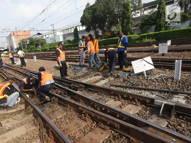 Petugas memperbaiki rel Kereta rel listrik (KRL) Jabodetabek rute Depok-Jatinegara yang mengalami anjlok di Stasiun Jatinegara, Jakarta Timur, Senin (30/10). Peristiwa itu berdampak keterlambatan perjalanan kereta lainnya. (Liputan6.com/Immanuel Antonius)