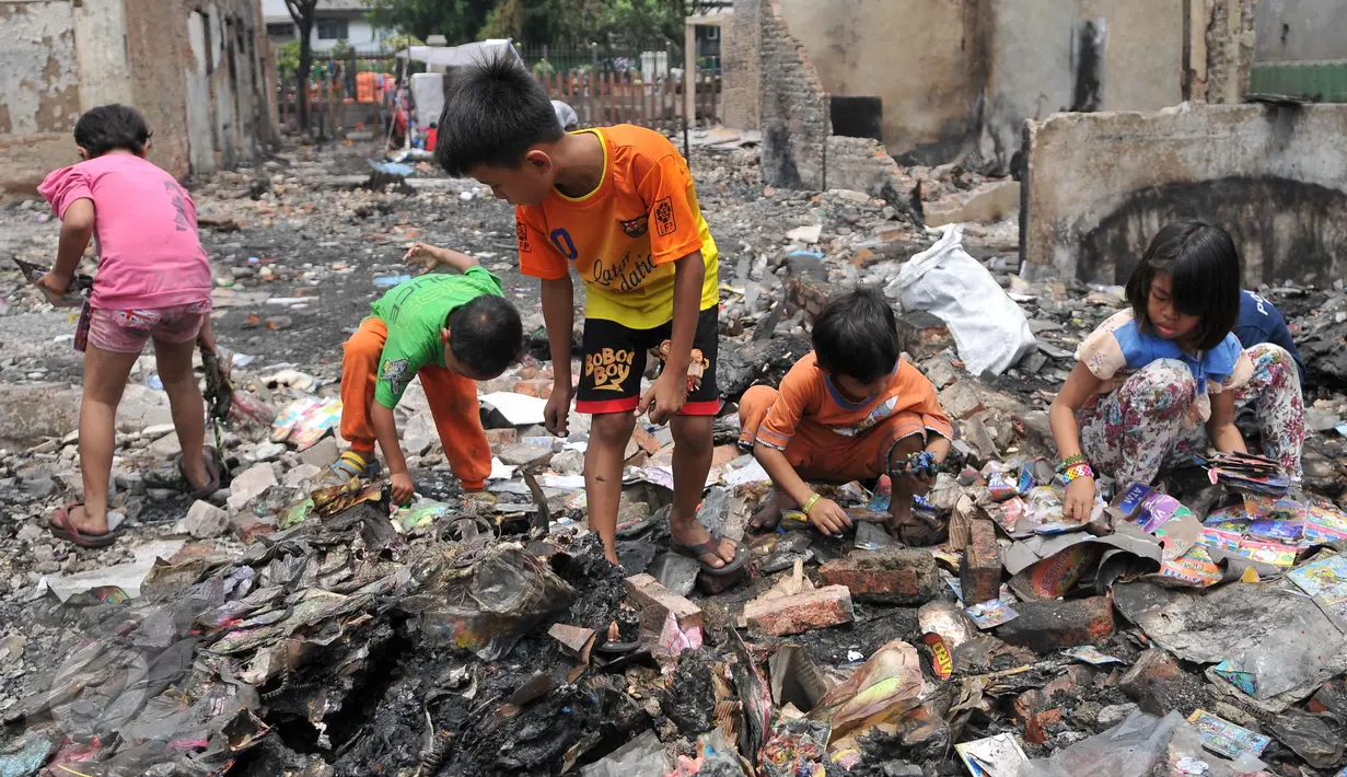 Sejumlah anak mengais mainan sisa kebakaran di Tambora, Jakarta, Senin (28/9/2015). Sejumlah warga Tambora memilih bertahan dan menolak direlokasi karena sudah puluhan tahun menetap di lokasi tersebut. (Liputan6.com/Gempur M Surya) 