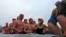 Peserta berbaris menuju tepi danau usai mengikuti lomba berenang di Danau Serpentine di Hyde Park, London, Inggris, Minggu (25/12). Lomba berenang di danau yang dingin ini sudah menjadi acara tahunan setiap perayaan natal. (REUTERS/Toby Melville)
