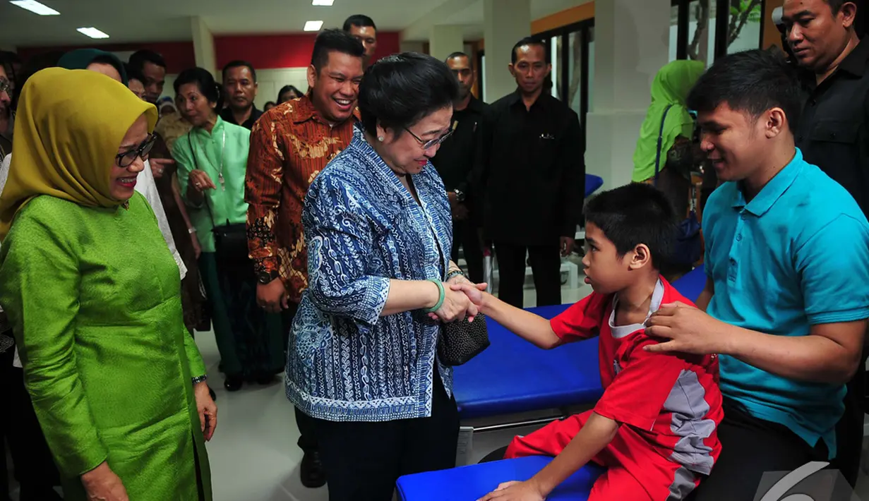 Megawati Soekarnoputri menyalami seorang anak saat menghadiri  acara 60 tahun Yayasan Pembinaan Anak Cacat (YPAC) Jakarta, Rabu (5/11/2014) (Liputan6.com/Johan Tallo)