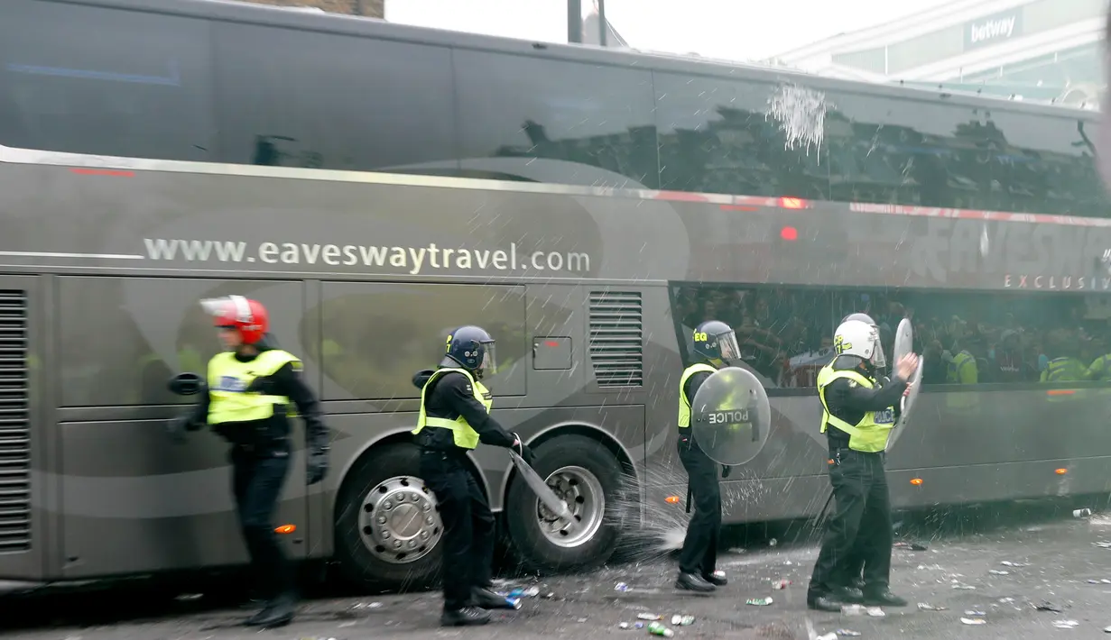 Suporter West Ham United menyerang bus skuat Manchester United di depan Stadion Boleyn Ground, Selasa (10/5). Aksi anarkis itu sampai melubangi jendela bus dan seorang polisi London serta satu warga dikabarkan mengalami luka ringan. (Reuters/Eddie Keogh)