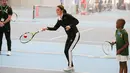 Kate Middleton berlatih main tenis saat mengunjungi Lawn Tennis Association di Pusat Tenis Nasional, London, Senin (31/10). Tak hanya berolahraga, Kate juga mendorong anak-anak usia 5-8 tahun, supaya menggemari olahraga itu. (Daniel LEAL-OLIVAS/POOL/AFP)