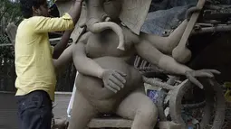 Seorang seniman India menyelesaikan pembuatan patung Dewa Hindu, Lord Ganesh di sebuah lokakarya di Hyderabad (19/8/2019). Festival Ganesh Chaturthi yang diadakan selama sebelas hari akan dirayakan mulai 2 September 2019. (AFP Photo/Noah Seelam)