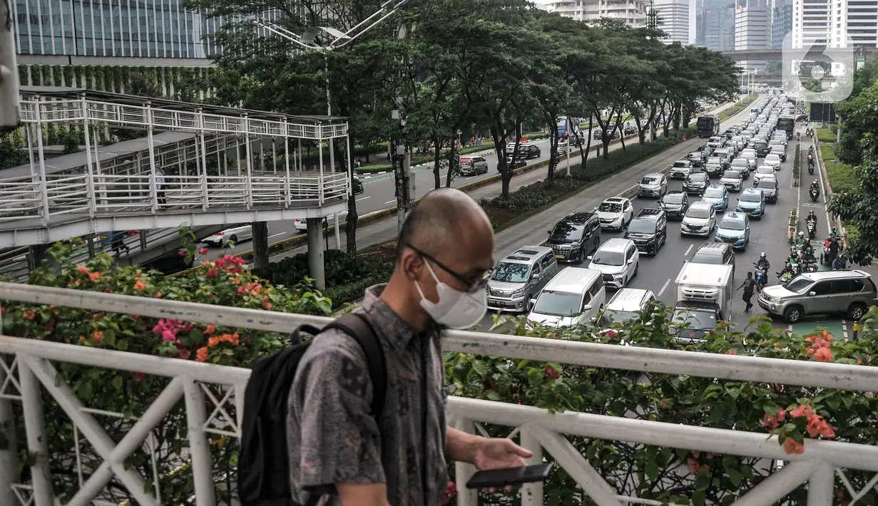 Pekerja melintasi JPO saat kemacetan kendaraan di Jalan Jenderal Sudirman, Jakarta, Senin (15/5/2023). (merdeka.com/Iqbal S Nugroho)