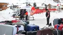 Sejumlah turis turun dari helikopter setelah dievakuasi dari resor ski Zermatt di  Taesch, Pegunungan Alpen Swiss (10/1). Sekitar 13.000 wisatawan terjebak akibat bencana tersebut. (AFP Photo/Fabrice Coffrini)