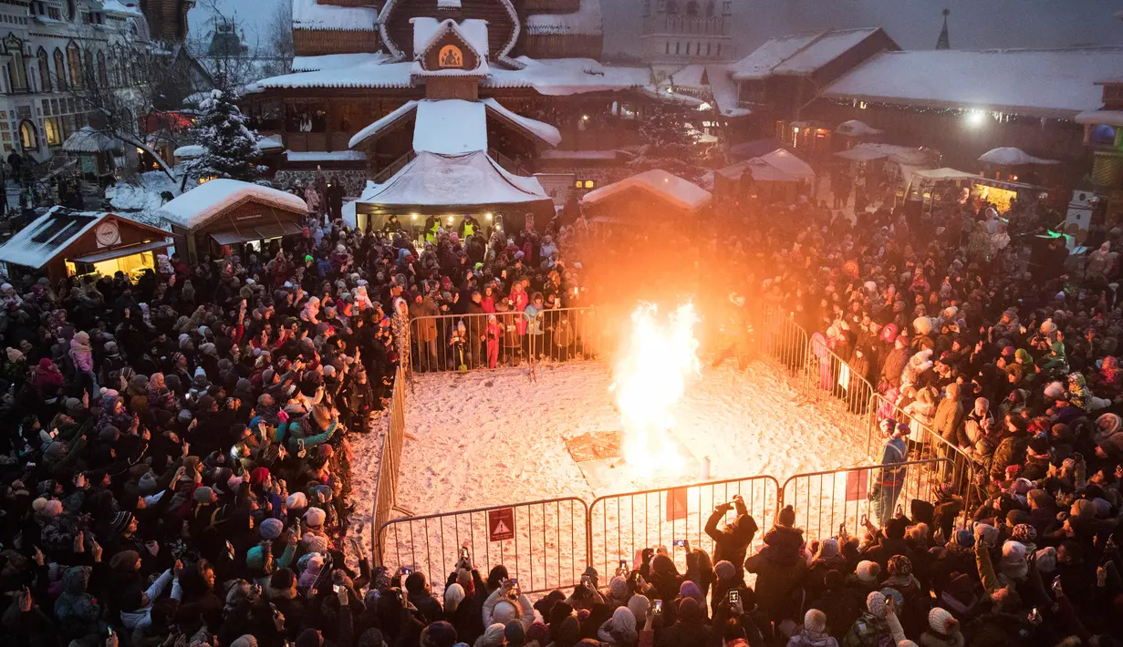 Orang-orang menonton patung Lady Winter yang dibakar saat perayaan Shrovetide di Moskow, Rusia (18/2). Shrovetide atau Maslenitsa adalah hari raya keagamaan dari Slavia Timur. (AP Photo / Pavel Golovkin)