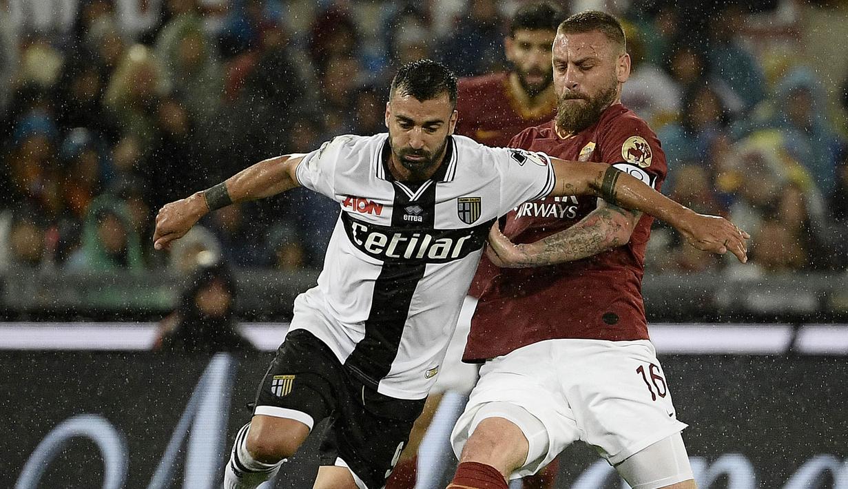 Gelandang AS Roma, Daniele De Rossi, berebut bola dengan striker Parma, Fabio Ceravolo, pada laga Serie A di Stadion Olympic, Roma, Minggu (26/5). Laga ini perpisahan bagi De Rossi dan AS Roma setelah 18 tahun. (AFP/Filippo Monteforte)