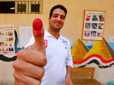 Seorang pria menunjukkan jarinya yang bertinta usai memberikan suaranya dalam referendum amandemen konstitusi di Kairo, Mesir, 20 April 2019. Masyarakat Mesir menggelar referendum untuk menentukan apakah Presiden Abdel Fattah al-Sisi diizinkan untuk memimpin hingga 2030. (REUTERS/Amr Abdallah Dalsh)