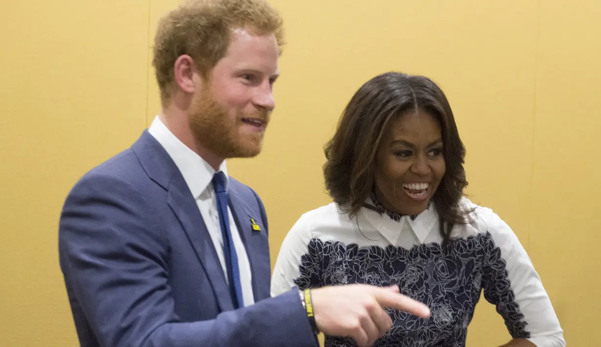 Pangeran Harry dan Michelle Obama tertawa saat menghadiri sebuah acara di Fort Belvoir, Virginia, Rabu (28/10). Pertemuan ini diadakan untuk mendukung pelaksanaan Invictus Games Orlando 2016 kepada para tentara yang terluka. (AFP PHOTO/SAUL Loeb)