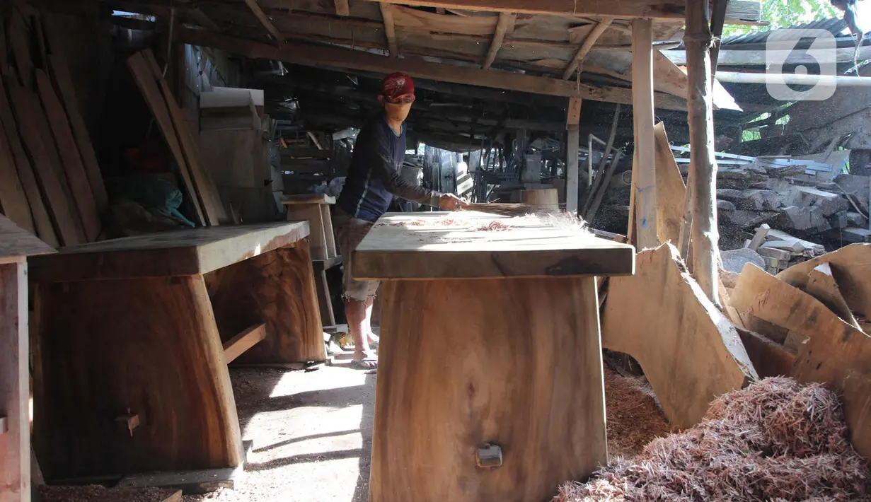 Perajin menyelesaikan pembuatan kursi dari kayu bekas di Pinang, Kota Tangerang, Banten, Minggu (28/3/2021). Furnitur berbahan dasar kayu bekas tersebut dijual dari harga Rp50.000 hingga lima juta rupiah dan dipasarkan hingga ke Sumatera dan Kalimantan. (Liputan6.com/Angga Yuniar)