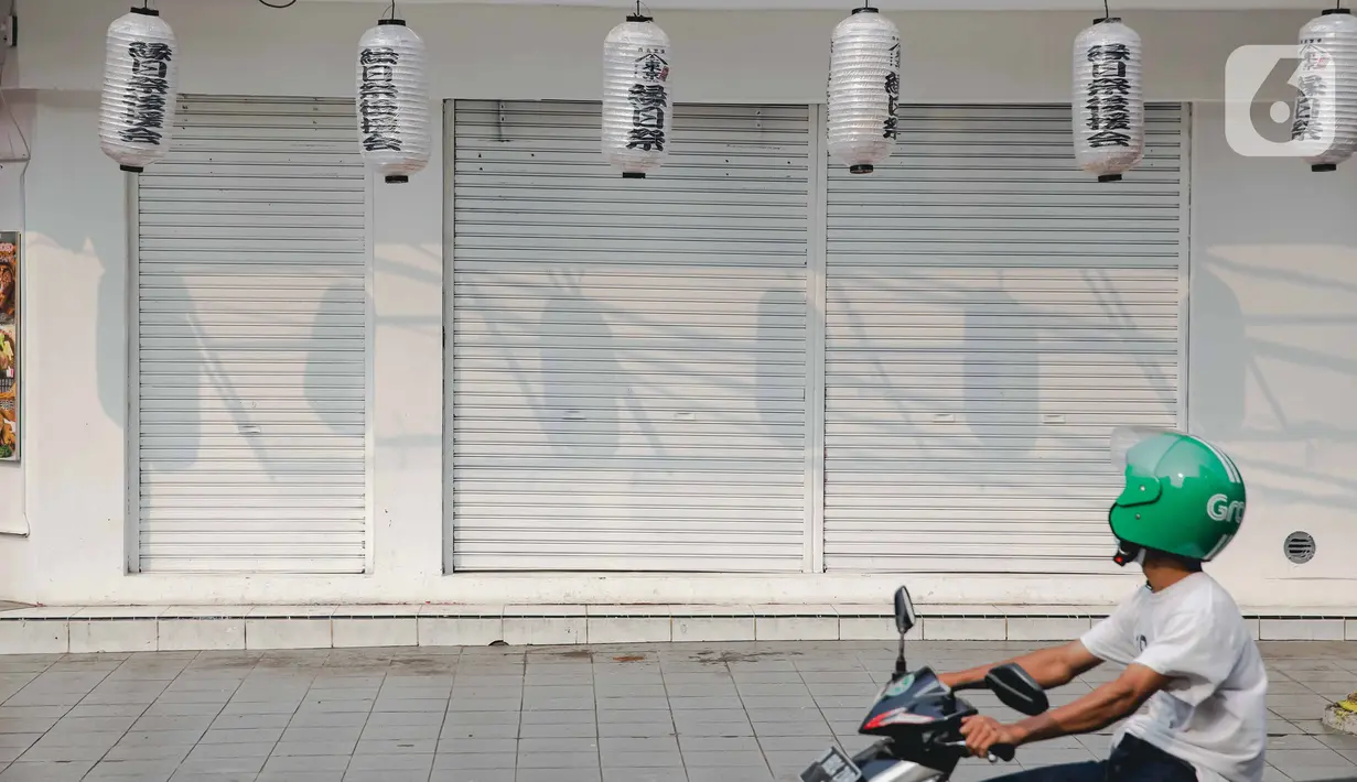 Pengendara motor melintas di depan pertokoan yang tutup di kawasan little Tokyo, Blok M, Jakarta, Rabu (21/7/2021). Pemerintah resmi menetapkan pemberlakuan pembatasan kegiatan masyarakat (PPKM) level 4 hingga 25 Juli mendatang untuk mencegah penyebaran virus Covid-19. (Liputan6.comn/Faizal Fanani)