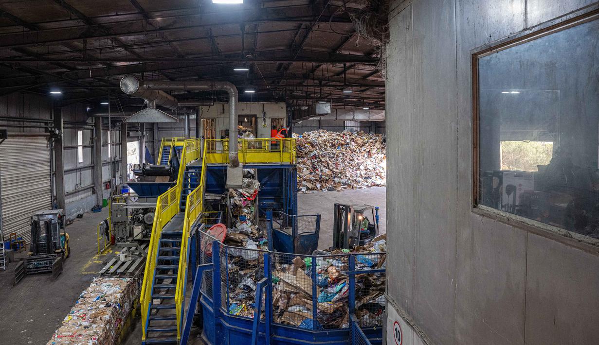 Sistem ini idealnya diawali dengan pemilahan sampah di sumbernya (rumah tangga, restoran, hotel, pabrik) ke dalam beberapa wadah berbeda. Tampak dalam foto yang menunjukkan pemandangan interior pabrik daur ulang di Corfu pada tanggal 15 Oktober 2025. (Angelos TZORTZINIS/AFP)